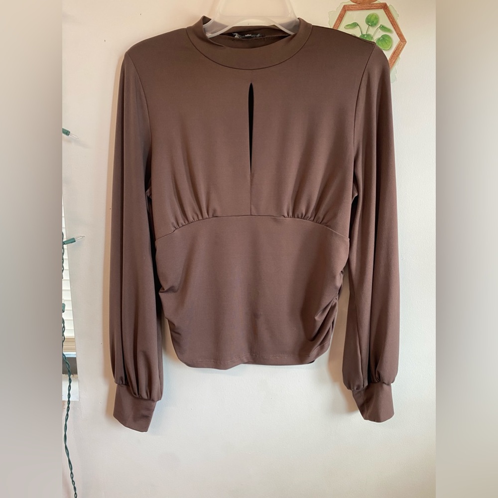 Brown flowy sleeve with small opening at chest.